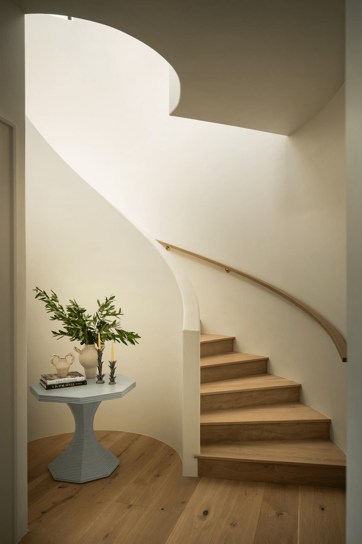 Curved custom staircase with wood treads and sculptural plaster walls