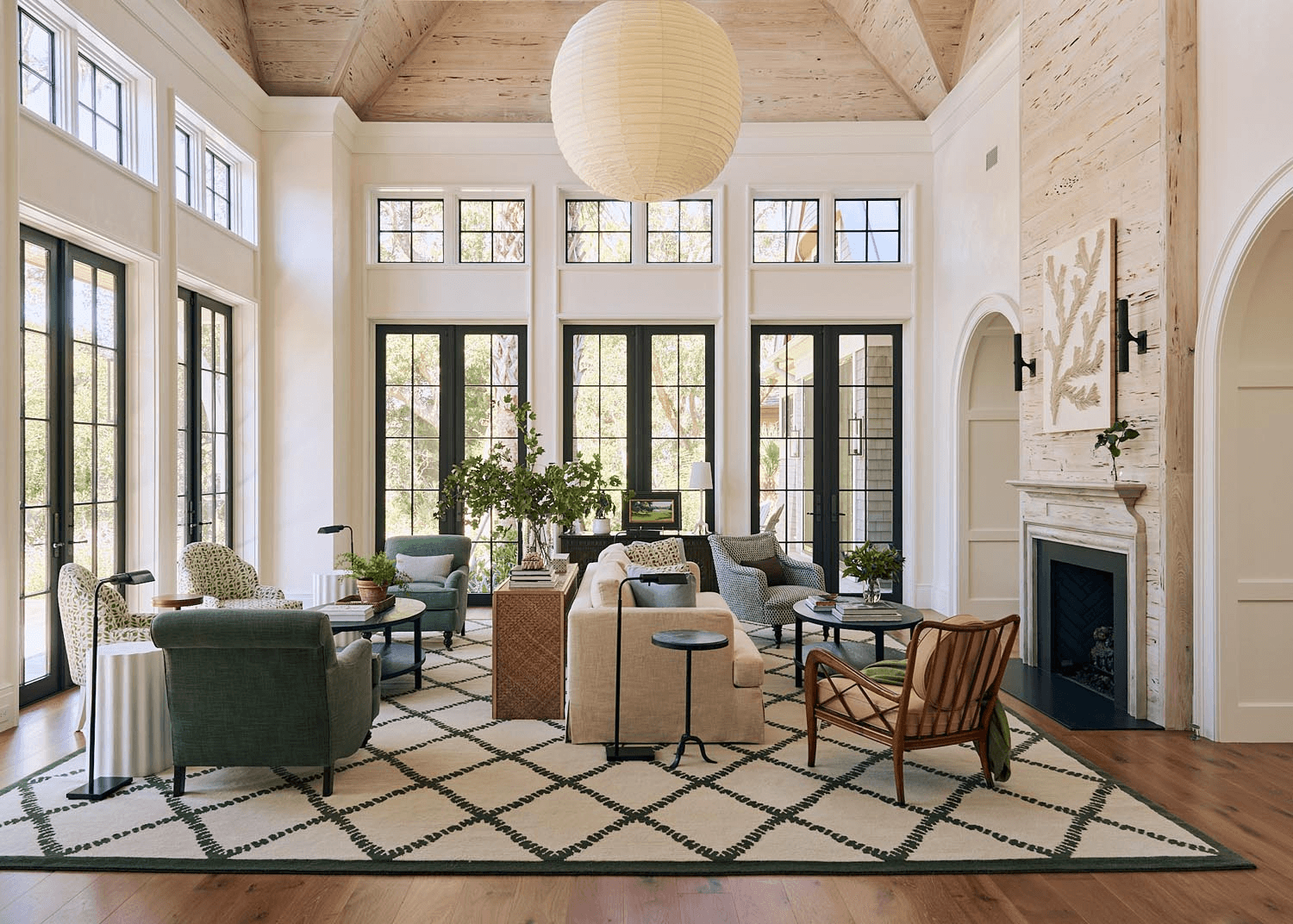 Luxury living room with vaulted wood ceiling and black-framed French doors