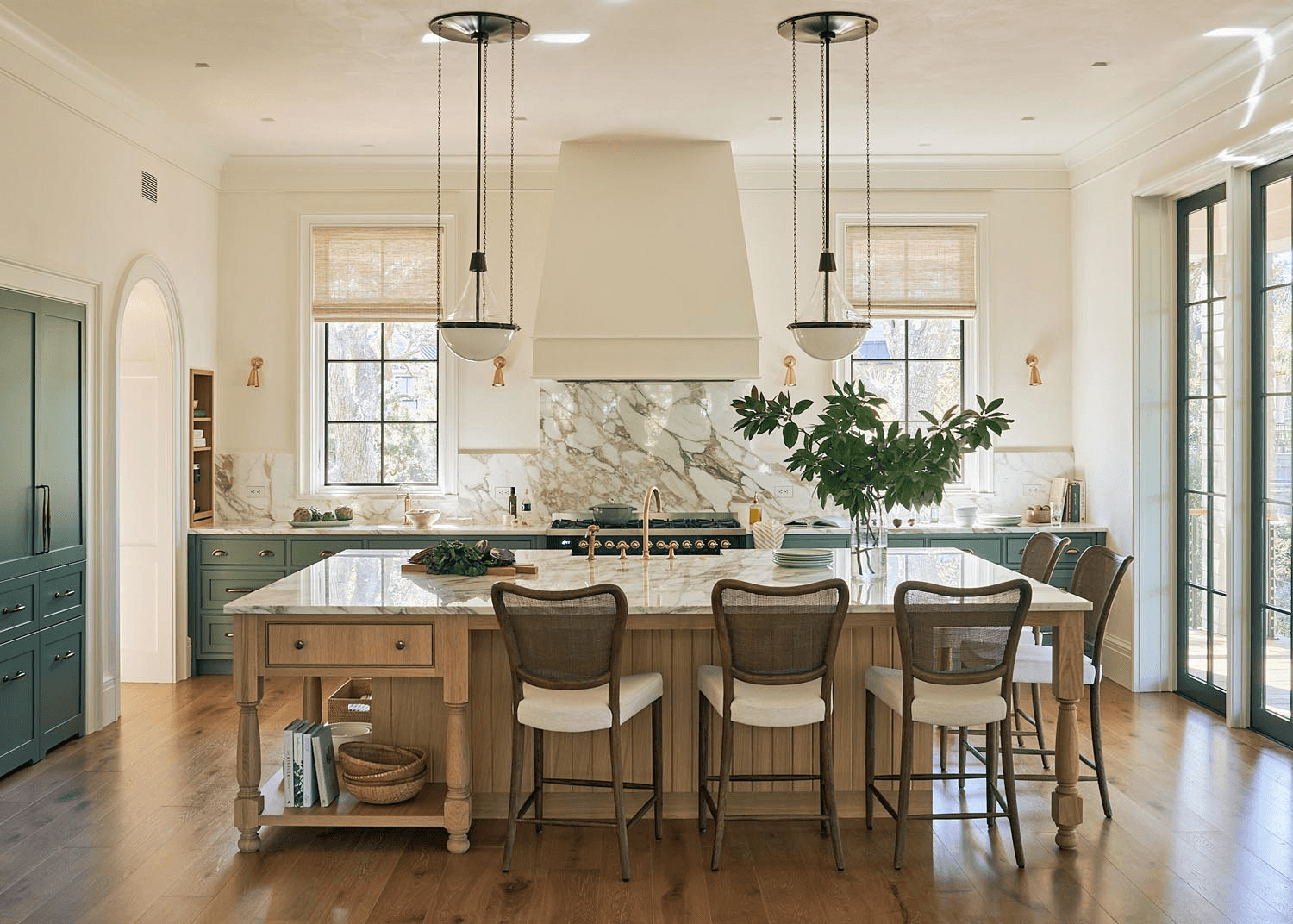 Luxury kitchen with marble island, wood cabinetry, and sage green accents