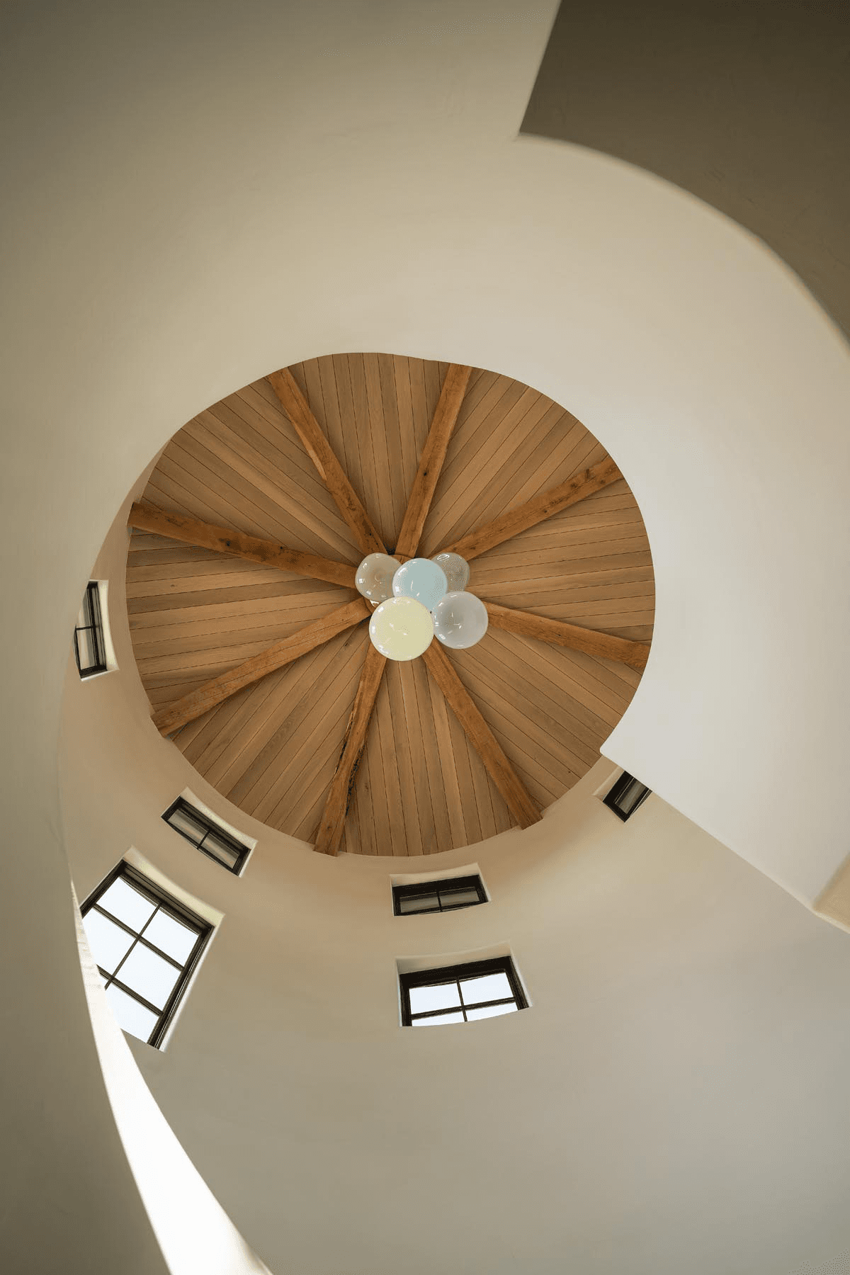 Custom vaulted ceiling with radial wood beams and refined lighting