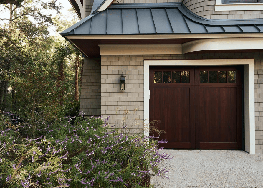 Custom residence exterior detail with wood garage doors and shingle siding