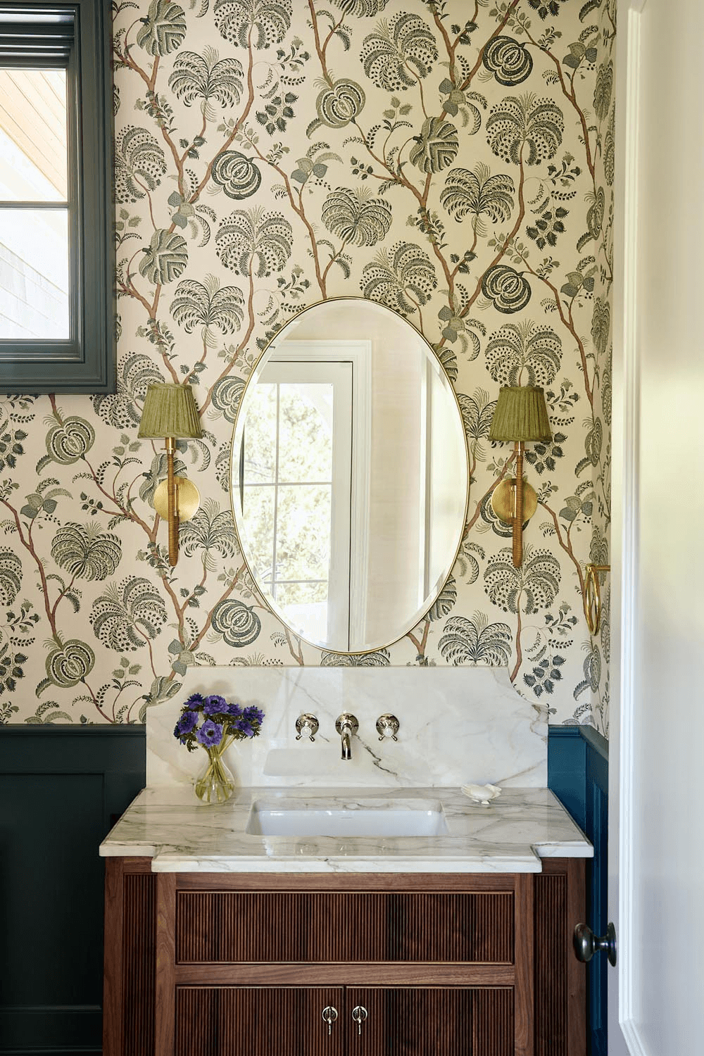 Custom powder room with fluted wood vanity, marble top, and botanical wallpaper