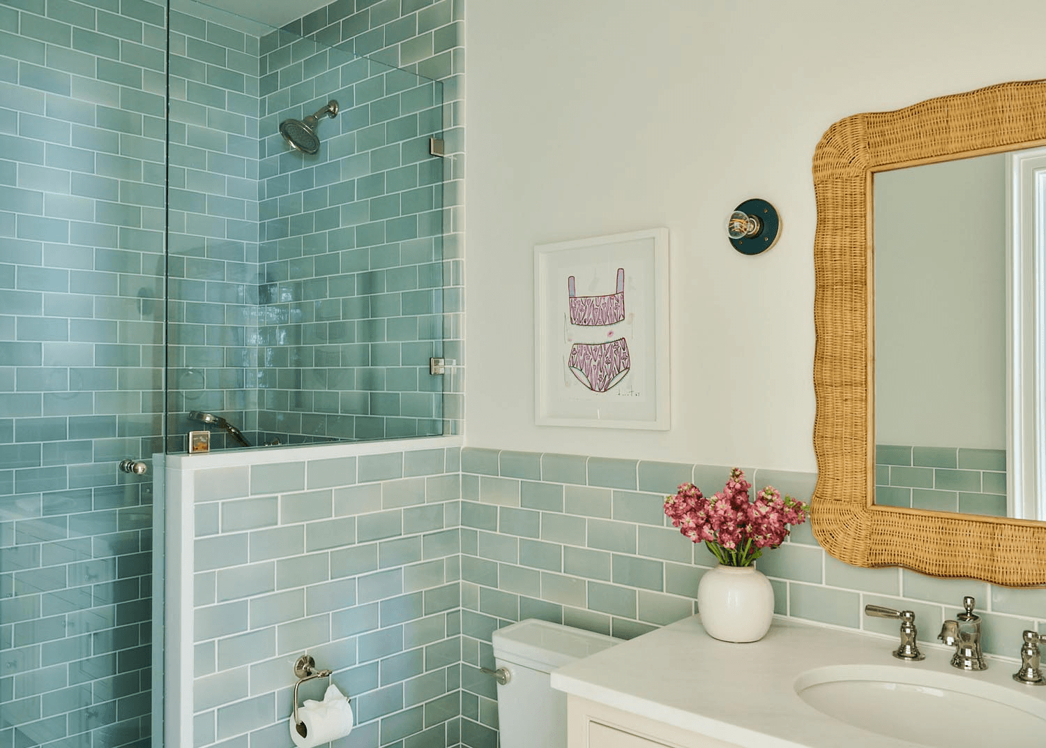 Custom bathroom with subway tile, woven mirror detail, and polished fixtures